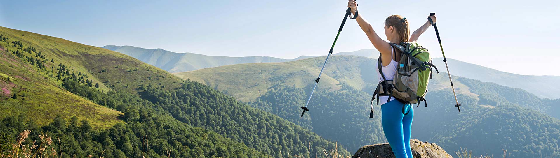 a hiker reaches the top of a mountain